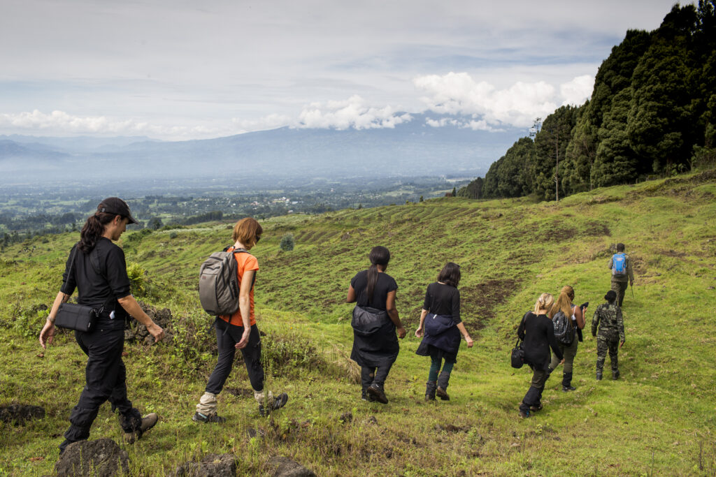 A group of Giving Pledge pledgers walking outdoors on a trail on a learning expedition.