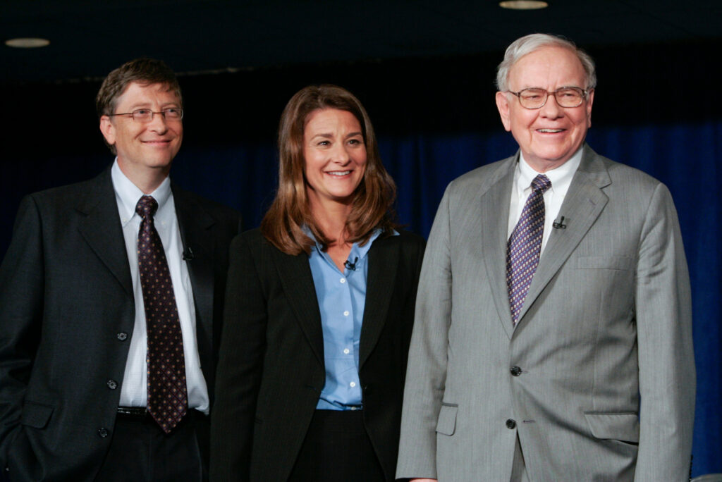 Giving Pledge founders Bill Gates, Melinda French Gates, and Warren Buffett standing in a row.