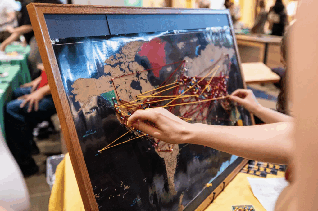 A global map with yarn and pin points connecting many locations on the map.